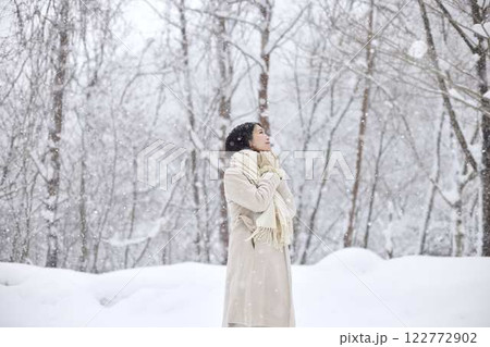冬の雪国に佇むマフラーを巻いた日本人女性 122772902