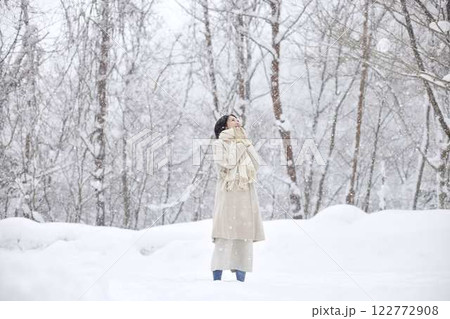 冬の雪国に佇むマフラーを巻いた日本人女性 122772908