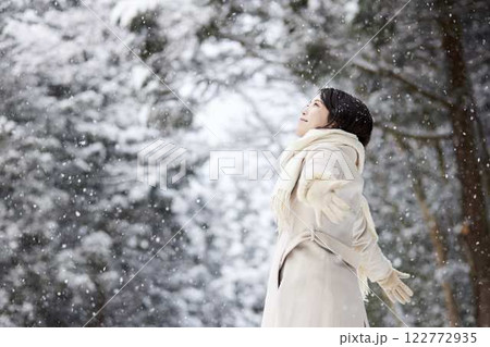 冬の雪国に佇むマフラーを巻いた日本人女性 122772935