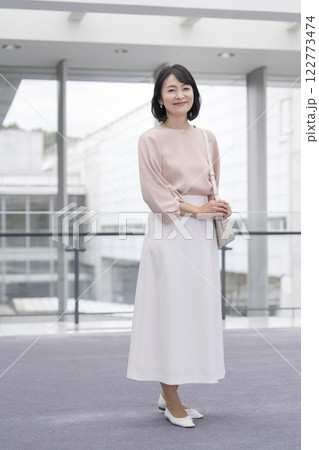 カメラ目線で微笑む50代の女性　全身　ポートレート 122773474