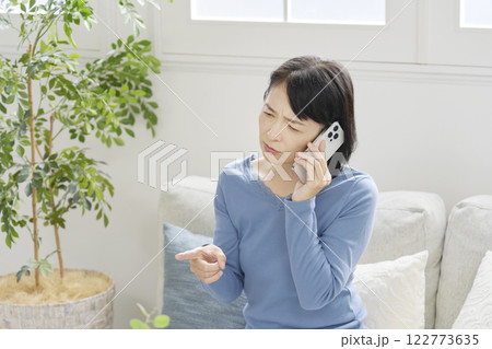 スマホでクレームの電話する中年女性　リビング 122773635