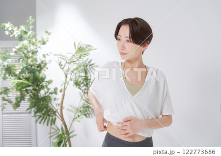 お腹の脂肪をつまむ女性 お腹の脂肪をつまむ女性 122773686