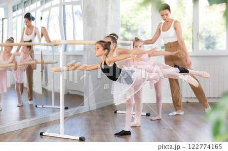 Little girls ballet lovers learn to perform arabesque pose in choreography studio 122774165