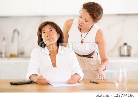 Two women discuss documents, try to solve financial problems 122774166