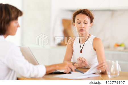 Female insurance agent tells woman the terms of property and life insurance Female insurance agent tells woman the terms of property and life insurance 122774197