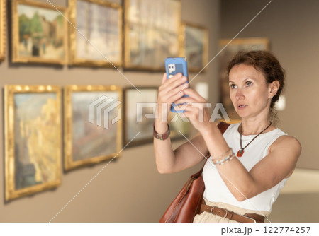 Adult woman taking photo of art gallery 122774257