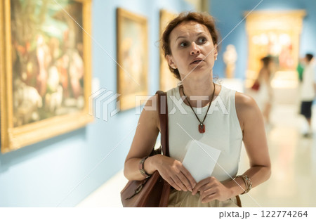 Woman looks at hall of paintings and sculptures Woman looks at hall of paintings and sculptures 122774264