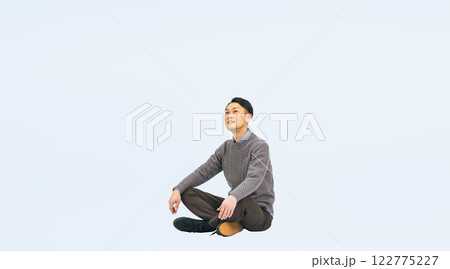 座って空を見上げるカジュアルウェアのミドル男性の全身写真 122775227