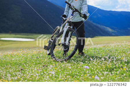 Riding mountain bike on flowering grassland mountain 122776342
