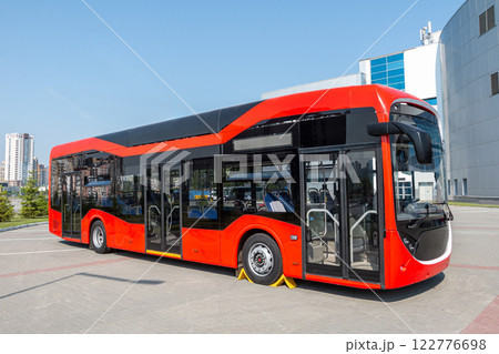 Red modern city bus at the bus station on a clear day Red modern city bus at the bus station on a clear day 122776698