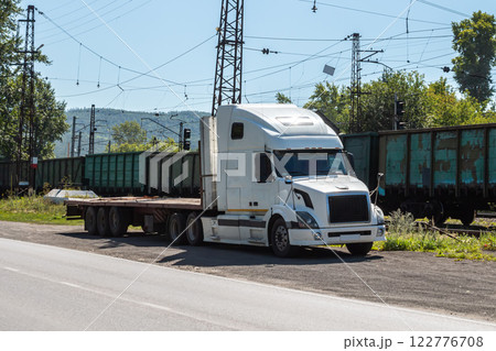White bonnet truck with a semitrailer at a freight railway station in the countryside White bonnet truck with a semitrailer at a freight railway station in the countryside 122776708
