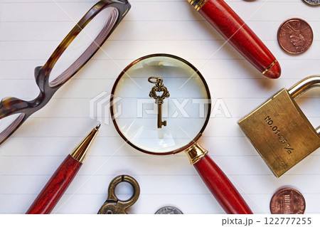 ノートの上の鍵とルーペ 122777255