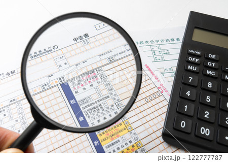 確定申告書を虫眼鏡で拡大 122777787