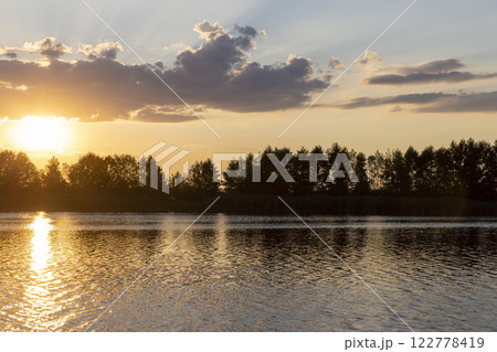 the lake with orange water in the summer at sunset the lake with orange water in the summer at sunset 122778419
