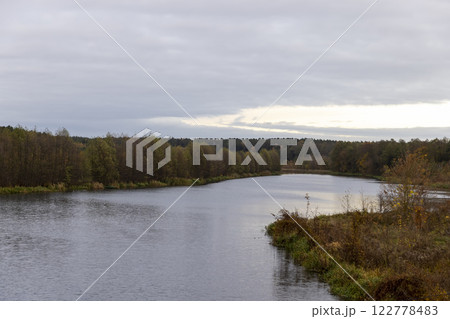 autumn landscape in cloudy weather with a lake and deciduous trees 122778483