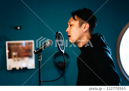 音響機材を前にレコーディングをする若い男性 音響機材を前にレコーディングをする若い男性 122778563