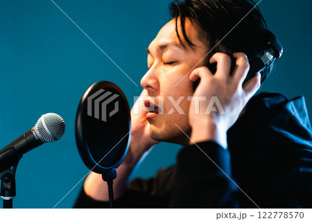 音響機材を前にレコーディングをする若い男性 音響機材を前にレコーディングをする若い男性 122778570