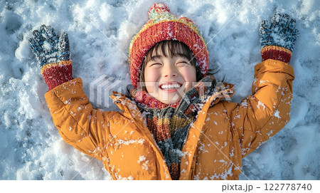 無邪気に雪の上に寝転んで笑う女の子 122778740