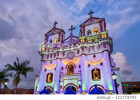 Vibrant sunset view of Church of Our Lady of Mount Carmel in Guatape - Antioquia, Colombia, beautifully lit with colorful lights and Christmas decorations Vibrant sunset view of Church of Our Lady of Mount Carmel in Guatape - Antioquia, Colombia, beautifully lit with colorful lights and Christmas decorations 122778793