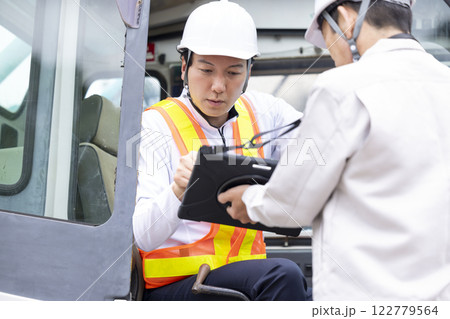 クレーン車の運転手 タブレットを見ながら作業内容を確認する男性 クレーン車の運転手 タブレットを見ながら作業内容を確認する男性 122779564