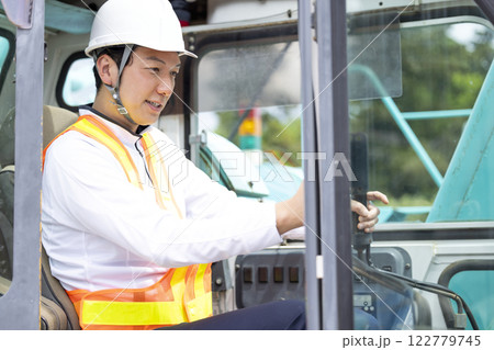 工事現場で働く作業員 クレーン車の運転をする男性 工事現場で働く作業員 クレーン車の運転をする男性 122779745