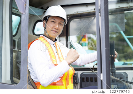 工事現場で働く作業員 クレーン車の運転をする男性 工事現場で働く作業員 クレーン車の運転をする男性 122779746
