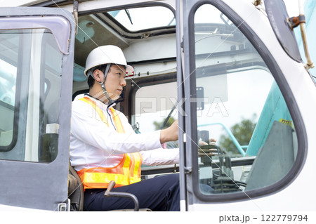 工事現場で働く作業員 クレーン車の運転をする男性 工事現場で働く作業員 クレーン車の運転をする男性 122779794