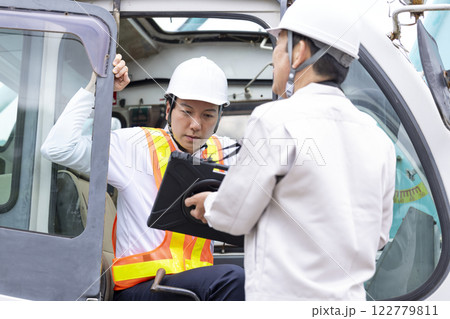 クレーン車の運転手 タブレットを見ながら作業内容を確認する男性 クレーン車の運転手 タブレットを見ながら作業内容を確認する男性 122779811