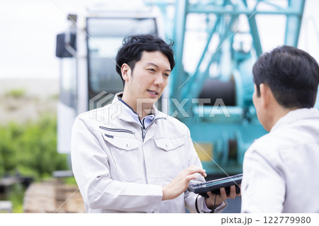 工事現場で働く作業員　タブレットで作業内容を確認する男性 122779980
