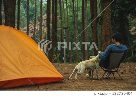 solo traveler in nature concept with asian man camping and see pink cherry blossom tree and pine tree with sunrise in springtime season 122780404