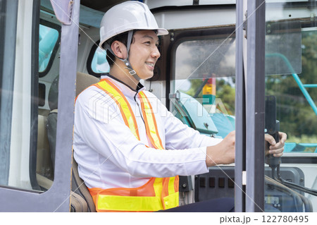 工事現場で働く作業員　クレーン車の運転をする男性 122780495