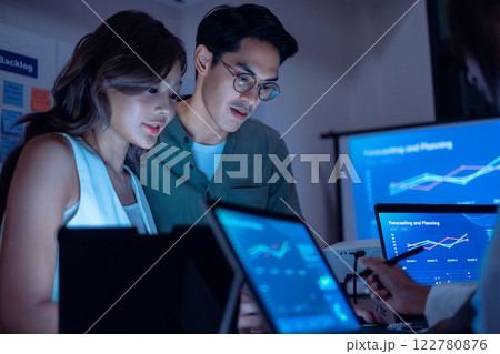 team of financial discussion budget planning, analyzing digital financial data and strategy in a modern office at night team of financial discussion budget planning, analyzing digital financial data and strategy in a modern office at night 122780876