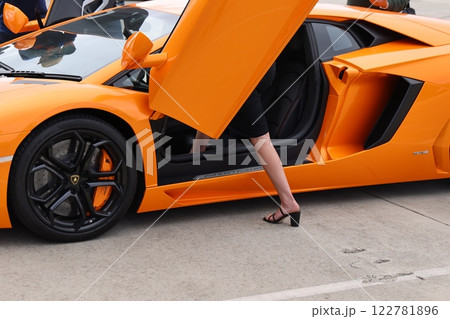 スーパーカーランボルギーニに乗り込む女性の足 122781896
