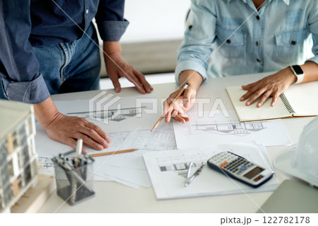 Architects and Engineers A man and woman are standing and sitting Architects and Engineers A man and woman are standing and sitting 122782178