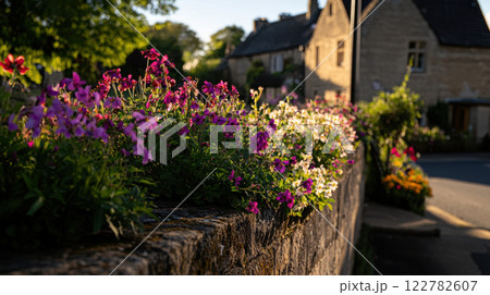 vibrant display of flowers along stone wall in village 122782607