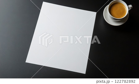 blank sheet of paper beside cup of coffee on dark table 122782892