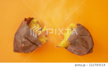 オレンジ色背景上の焼き芋（サツマイモ）と湯気。 122783514