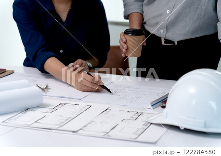 Architects or engineers are pointing at plans to discuss project design Architects or engineers are pointing at plans to discuss project design 122784380