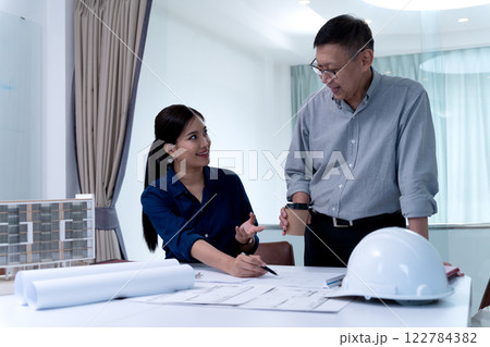 Architects or engineers are pointing at plans to discuss project design Architects or engineers are pointing at plans to discuss project design 122784382
