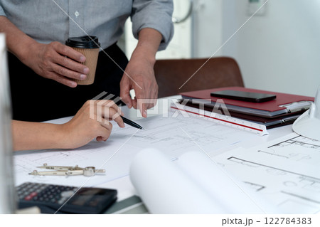 Architects or engineers are pointing at plans to discuss project design Architects or engineers are pointing at plans to discuss project design 122784383