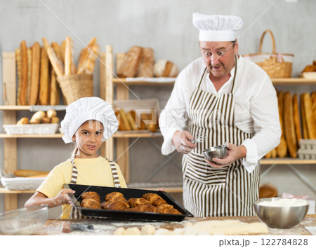 Surprised father looks at cooked croissants, rejoices at result of daughters work Surprised father looks at cooked croissants, rejoices at result of daughters work 122784828