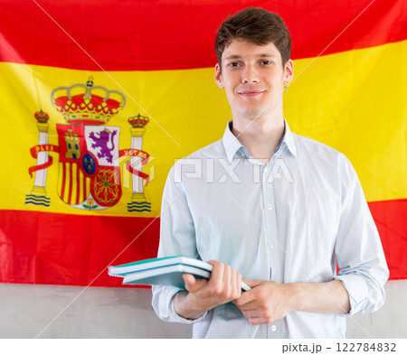 Positive student on background of flag of Spain - concept of studying abroad and immigration Positive student on background of flag of Spain - concept of studying abroad and immigration 122784832