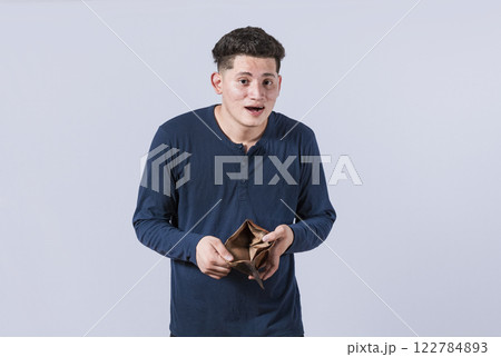 unhappy and surprised man looking in an empty wallet, man seeing his empty wallet, young man with wallet without money 122784893