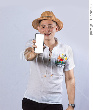Man with beach hat showing the screen of his cell phone, beach man showing the screen of the cell phone Man with beach hat showing the screen of his cell phone, beach man showing the screen of the cell phone 122784909