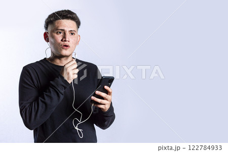 handsome man talking with headset holding cellphone , young man in glasses with earphones isolated 122784933