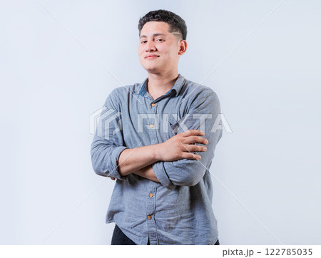 Portrait of smiling latin man with arms crossed isolated. Young casual latin man smiling at camera. Smiling young nicaraguan man isolated 122785035