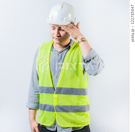 Worried young engineer holding forehead isolated. Frustrated young engineer holding forehead and looking down. Worried male engineer man holding forehead Worried young engineer holding forehead isolated. Frustrated young engineer holding forehead and looking down. Worried male engineer man holding forehead 122785047