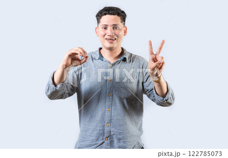 Interpreter man gesturing LOVE AND PEACE in sign language isolated. Smiling person making gesture LOVE AND PEACE in sign language 122785073