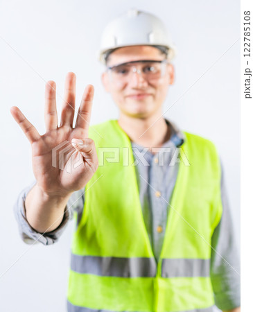 Young engineer counting number four isolated. Male engineer showing number four with fingers isolated Young engineer counting number four isolated. Male engineer showing number four with fingers isolated 122785108