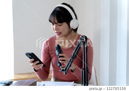 Young asian woman are using smart phones along with other forms of communication 122785150